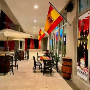 Terraza del Restaurante Español Echate Pa Lla con ambiente autentico español, con sillas altas y barriles